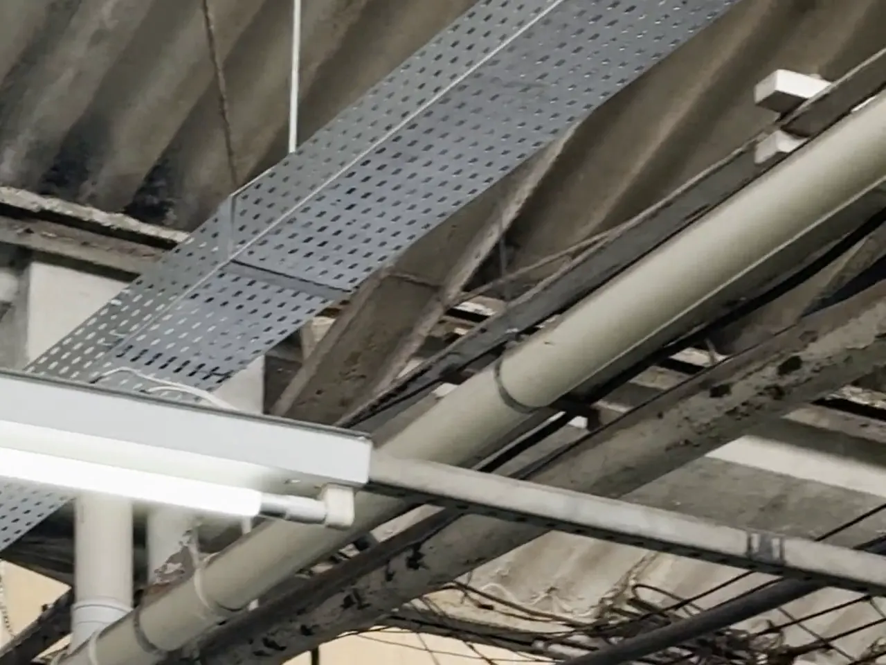 Eletrocalhas e infraestrutura elétrica instaladas no teto de um galpão